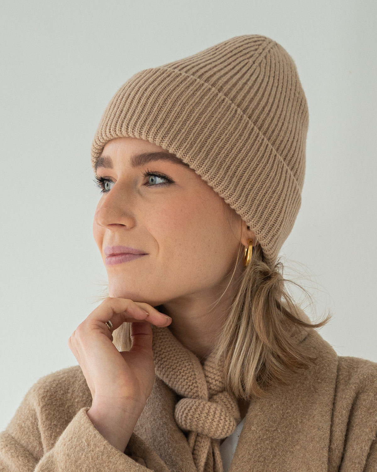 eine frau trägt eine mütze in beige