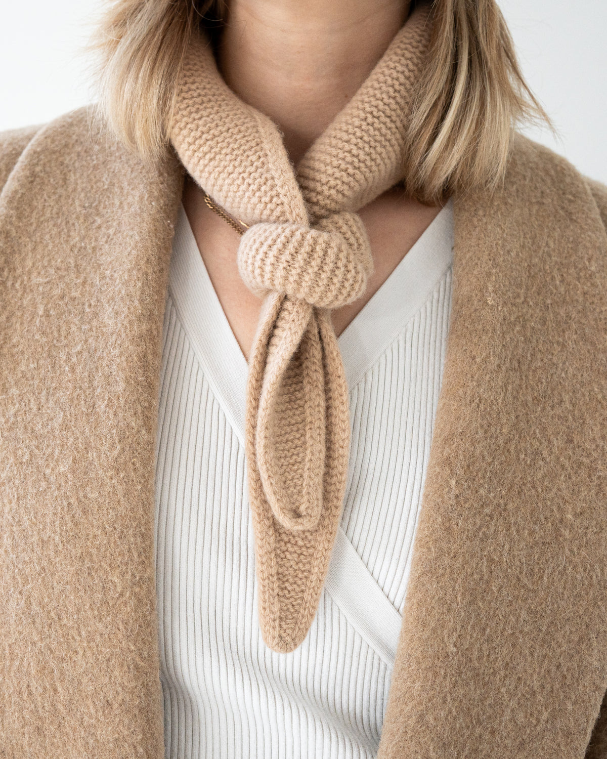 ein beiger mini scarf, gewickelt um einen hals