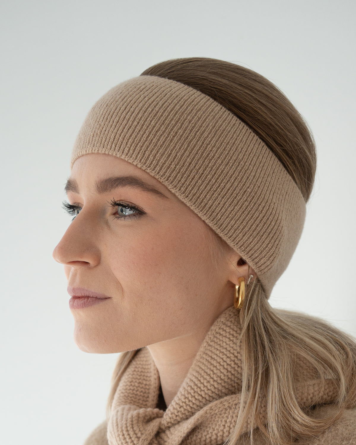eine frau trägt ein stirnband in beige