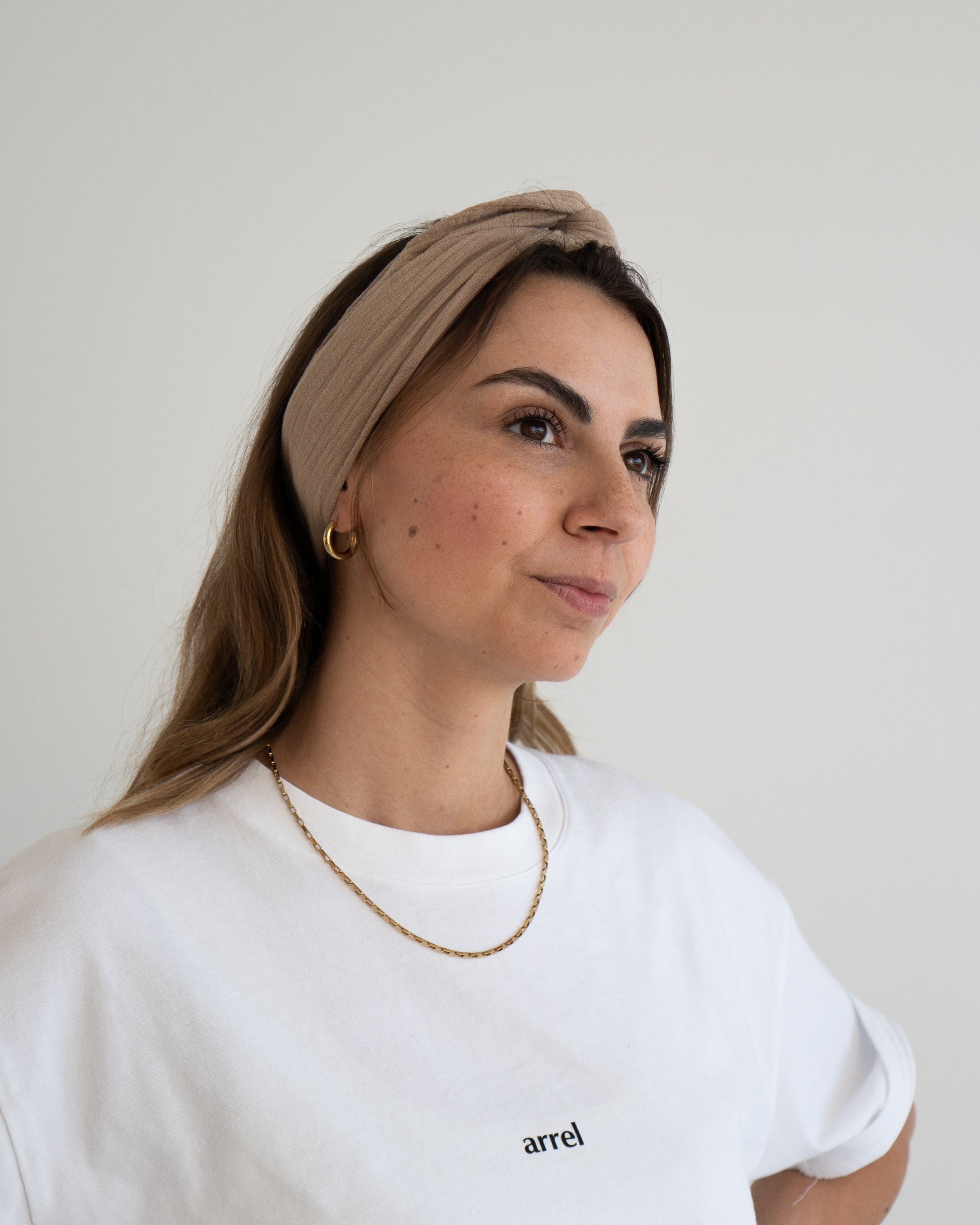 eine frau trägt ein haarband in beige