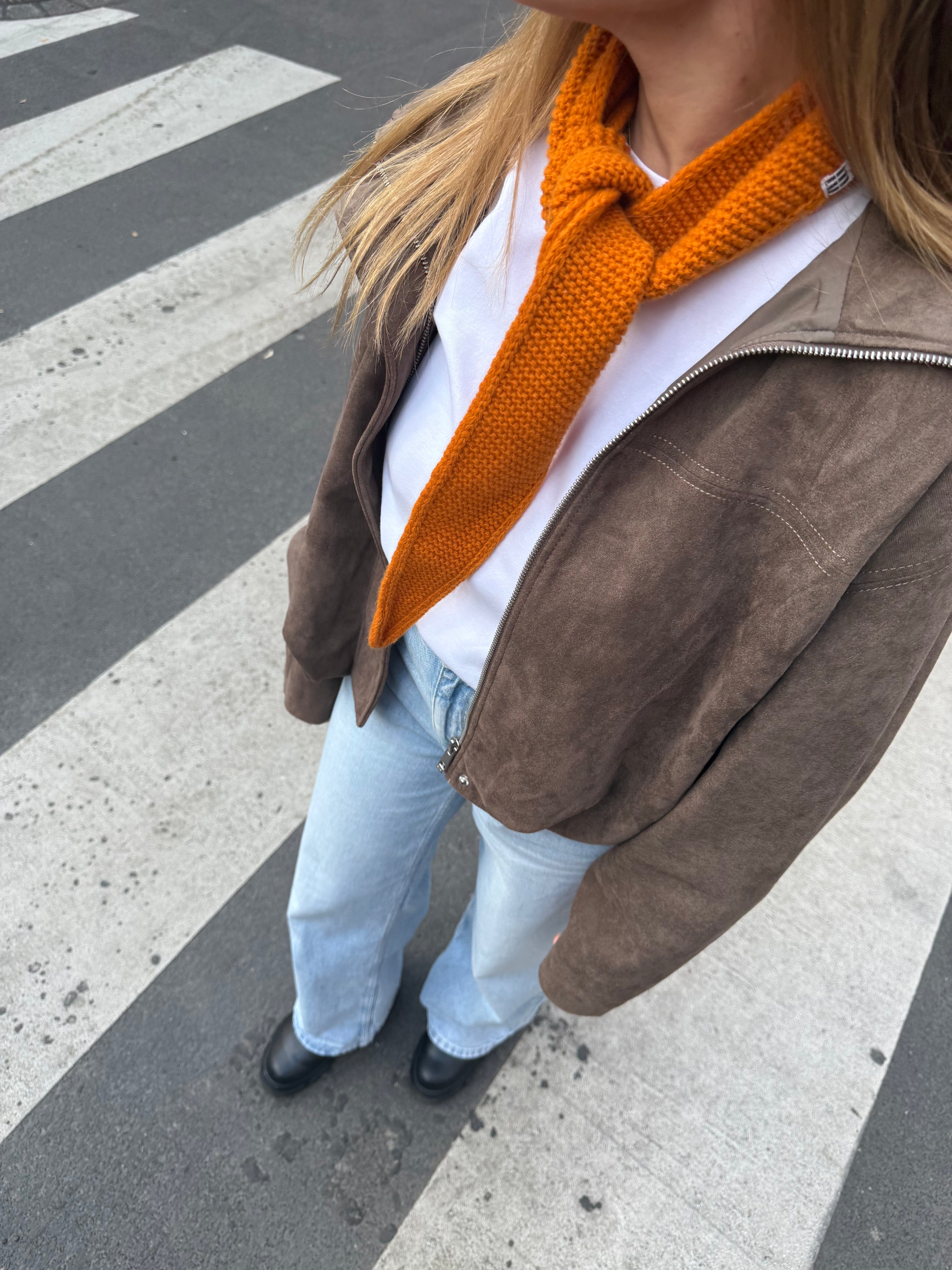 eine frau trägt einen mini schal  in orange auf der straße