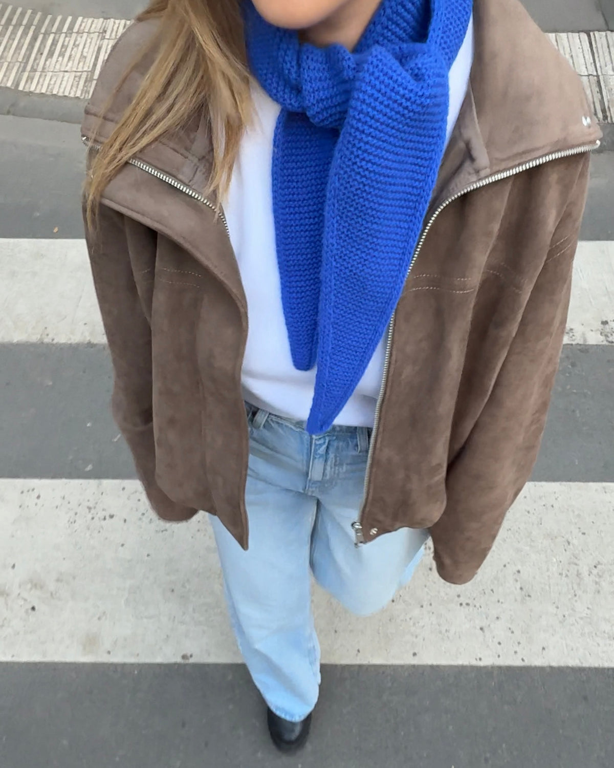 eine frau trägt einen mini schal in blau und geht über die straße