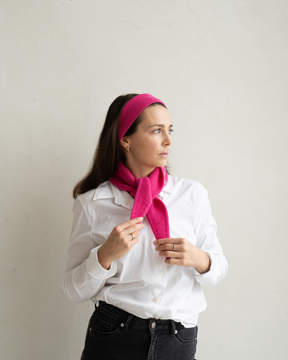 eine frau trägt einen mini schal und ein stirnband in rosa