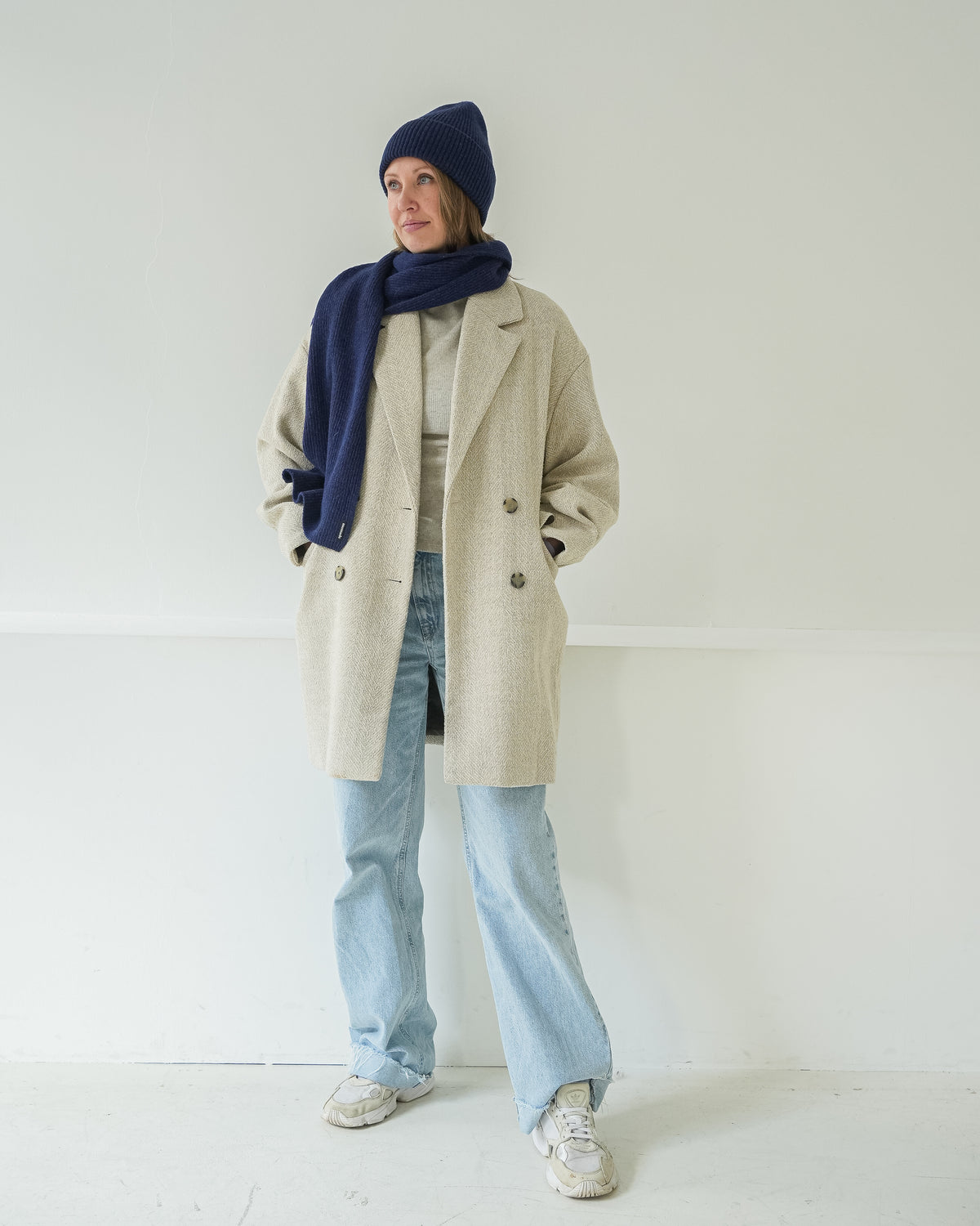 eine frau trägt einen schal und eine mütze in blau