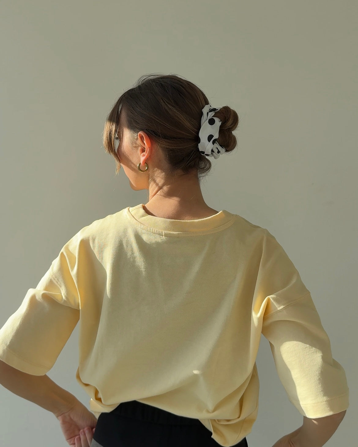 rückansicht einer frau, die ein weißes haarband mit schwarzen punkten trägt